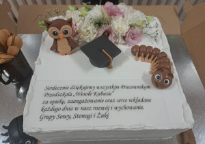 Tort z napisem "Serdecznie dziękujemy wszystkim Pracownikom Przedszkola Wesołe Kubusie za opiekę, zaangażowanie oraz serce wkładane każdego dnia w nasz rozwój i wychowanie. Grupy Sowy, Stonogi i Żuki.