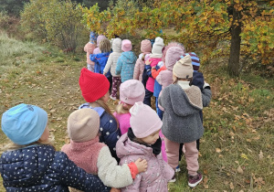Dzieci idą w kierunku Osady Przygoda, poznając otoczenie i odkrywając uroki przyrody.
